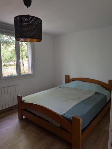 a bedroom with a bed and a lamp and a window at Cottage near Clisson in Gétigné