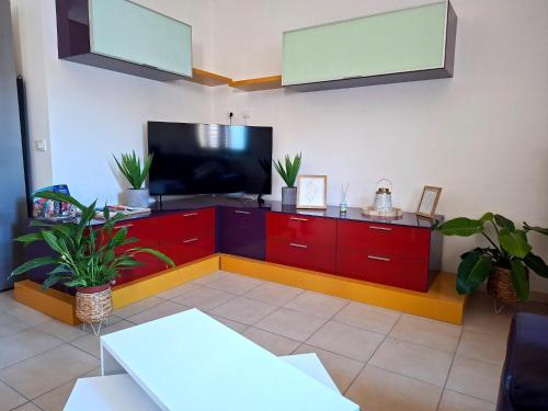 a living room with a tv and red cabinets at Country house in Iglesias