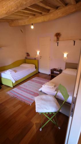 a room with two beds and a chair in it at da Francesco rooms in Lucca