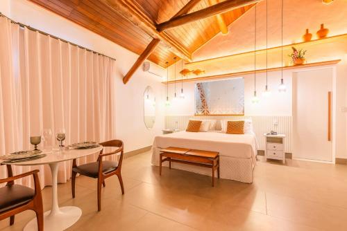 a bedroom with a bed and a table and a dining room at Aruanã Eco Praia Hotel in Aracaju