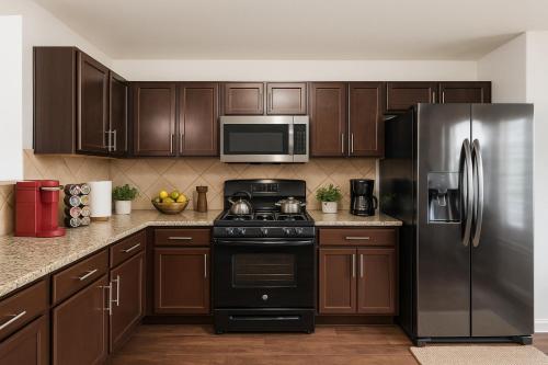 una cucina con mobili in legno e un frigorifero in acciaio inossidabile di Kitchen Foosball Fenced Yard Parking a Kyle