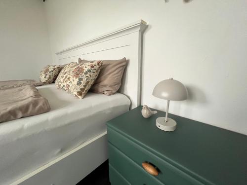 a bedroom with a bed and a lamp on a dresser at Ferienwohnung Sort Sol Grellsbülldeich 7 in Aventoft