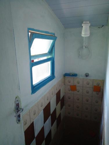 a small bathroom with a window and a tub at Naviooceanico in Saquarema