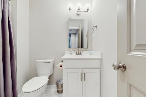 a bathroom with a toilet and a sink and a mirror at Beaufort Villas #A in Beaufort