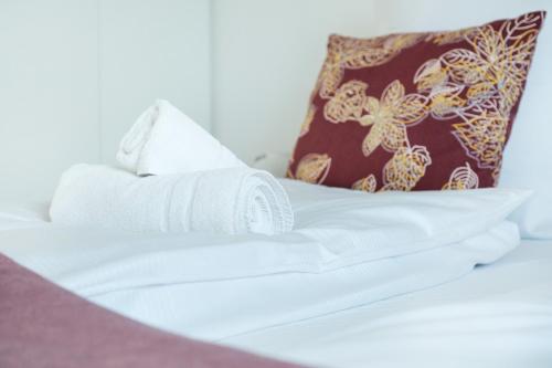 a white bed with a towel on it with a pillow at Cocoon am Schloß in Lochau