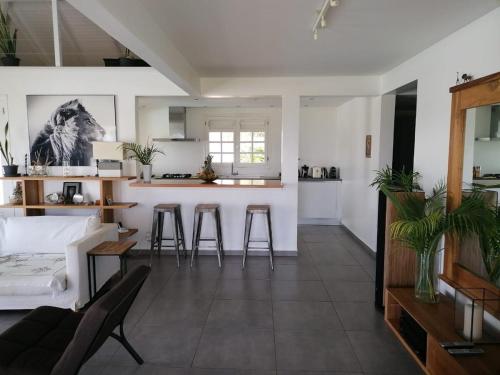 a living room and kitchen with a couch and chairs at Very nice villa with pool, sea view, large land in Le Gosier