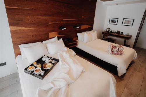 a hotel room with two beds and a tray of food at La Urumpta Hotel, AKEN MIND in Río Cuarto