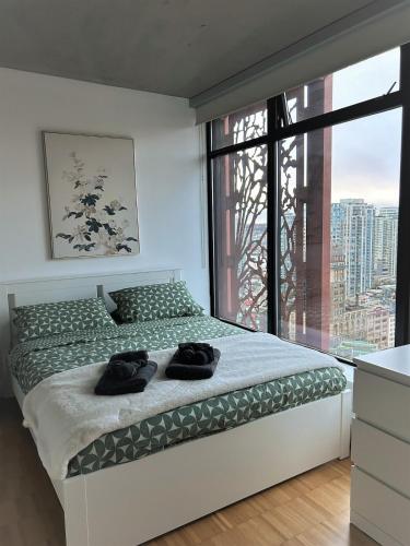 a bedroom with a bed and a large window at Cozy Gastown condo with a view! in Vancouver
