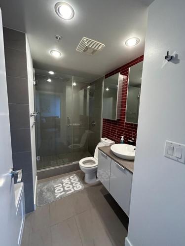 a bathroom with a toilet and a shower and a sink at Cozy Gastown condo with a view! in Vancouver