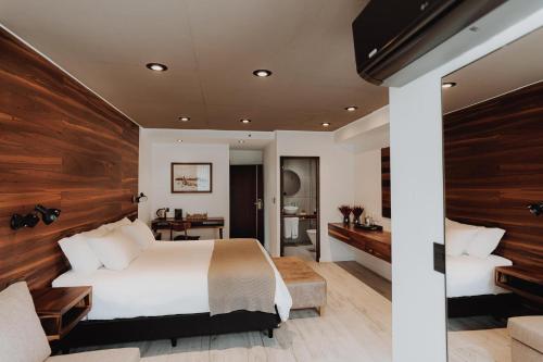 a bedroom with a large bed with a wooden wall at La Urumpta Hotel, AKEN MIND in Río Cuarto