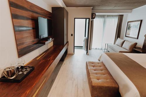 a hotel room with a bed and a couch at La Urumpta Hotel, AKEN MIND in Río Cuarto