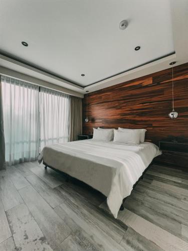 a bedroom with a large bed with a wooden wall at La Urumpta Hotel, AKEN MIND in Río Cuarto