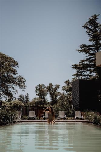 a woman standing in the water in a swimming pool at La Urumpta Hotel, AKEN MIND in Río Cuarto