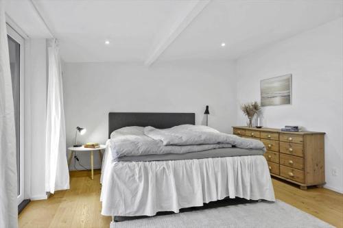 a white bedroom with a bed and a dresser at 30476-Odder-Hulager-9 in Odder