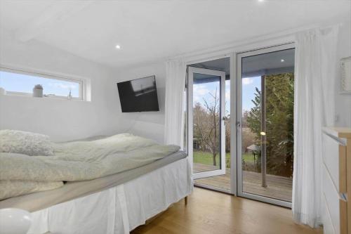 a white bedroom with a bed and a window at 30476-Odder-Hulager-9 in Odder