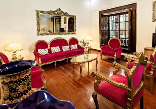 a living room with red furniture and a mirror at Gran Bolivar Hotel - Trujillo, Perú in Trujillo