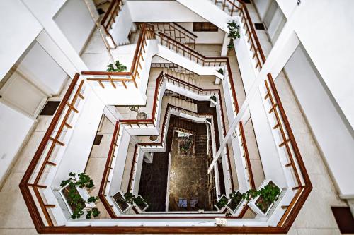 an overhead view of a spiral staircase with plants at Gran Bolivar Hotel - Trujillo, Perú in Trujillo