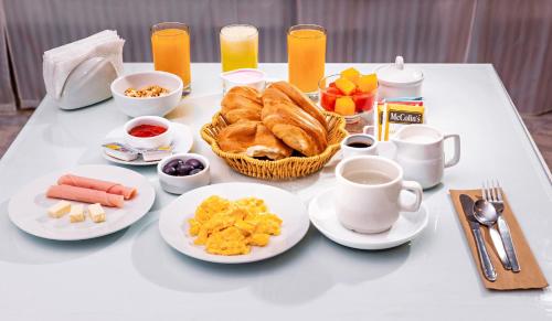 a table topped with plates of breakfast foods and coffee at Gran Bolivar Hotel - Trujillo, Perú in Trujillo
