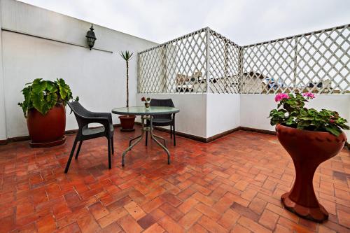 a room with a table and chairs and potted plants at Gran Bolivar Hotel - Trujillo, Perú in Trujillo