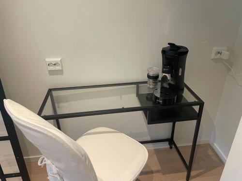 a glass table with a coffee maker and a chair at Modern and nice apartment, near the university, UIA in Kristiansand