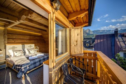 a room with a bed on a balcony at Willa Malinowa in Zakopane