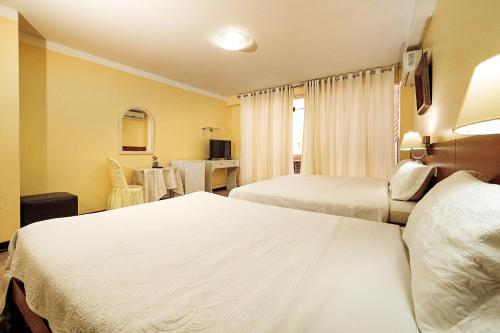a hotel room with two beds and a table at Gran Bolivar Hotel - Trujillo, Perú in Trujillo