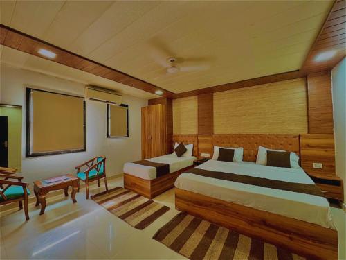 a hotel room with two beds and a screen at Hotel Nysha Delhi in New Delhi