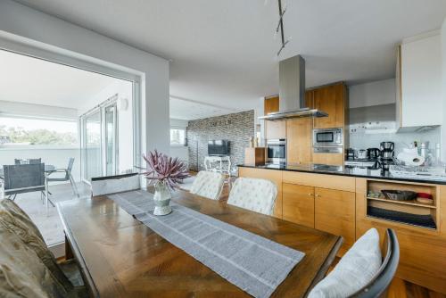 a kitchen and dining room with a wooden table at Cocoon am See in Lochau