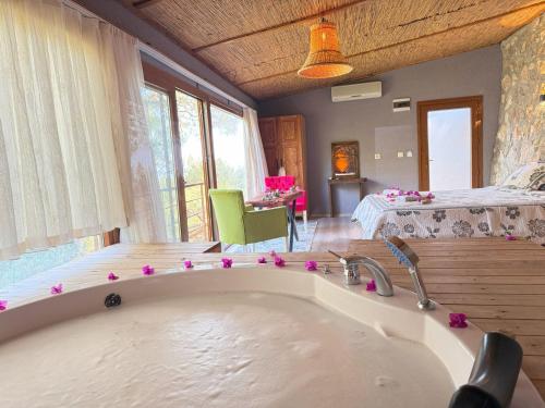 a large bath tub with pink flowers on it in a room at Manzara Bungalov in Fethiye