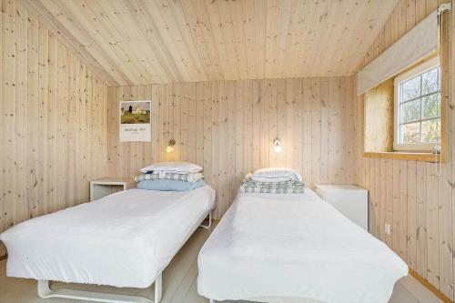 duas camas em um quarto com paredes de madeira em 30462-Odder-Kirkeager-7 em Odder