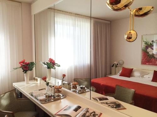 a hotel room with a bed and a mirror at Starhotels Cristallo Palace in Bergamo