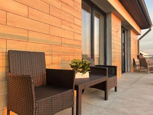 a patio with a table and chairs on a building at Apartamenty Na wzgórzu in Ińsko