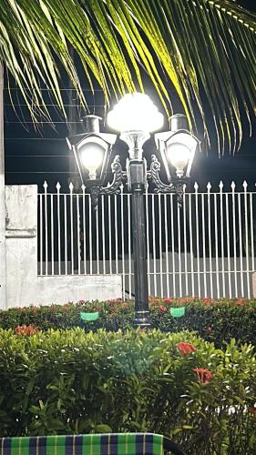 a street light in front of a white fence at Casa de veraneio in Salinópolis