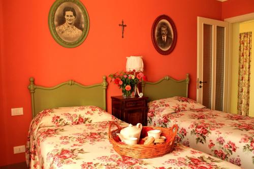 two twin beds in a room with red walls at LA CUCCAGNA DI DON BOSCO - No landlords and neighbours - Absolute privacy! in Montafia