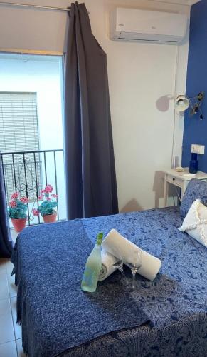 a blue bed with a bottle and glasses on it at Casa del Mar a la Sierra in Setenil