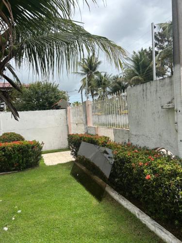 a park bench in a yard next to a fence at Casa de veraneio in Salinópolis
