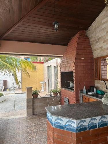 an outdoor patio with a kitchen and a brick wall at Casa de veraneio in Salinópolis