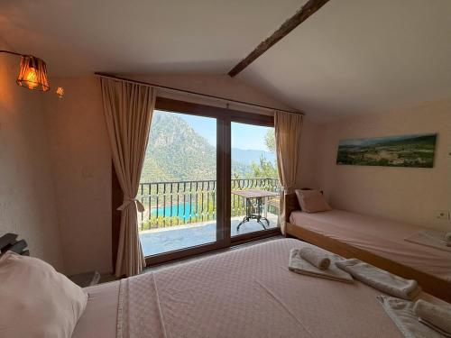 a bedroom with two beds and a large window at Manzara Bungalov in Fethiye