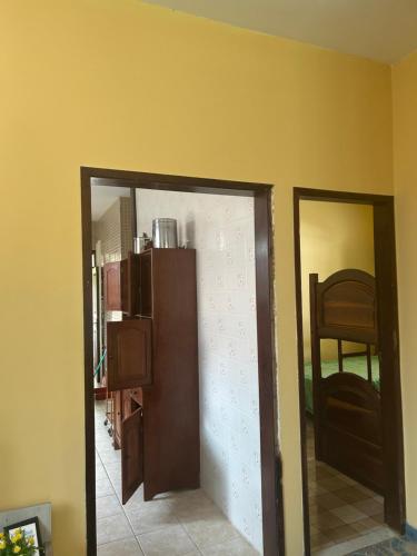 a door to a room with a chair and a mirror at Casa de veraneio in Salinópolis