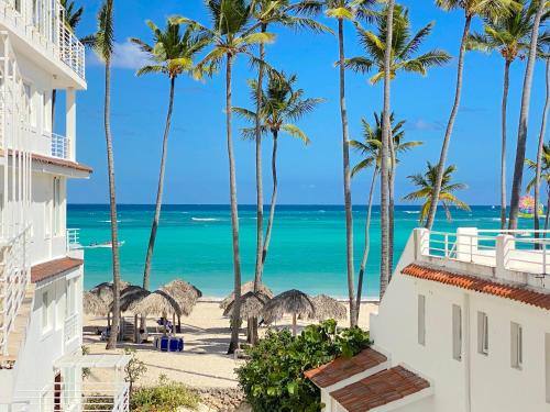 a view of the beach from the balcony of a resort at SANDY BAY VILLAS and SUITES playa LOS CORALES in Punta Cana
