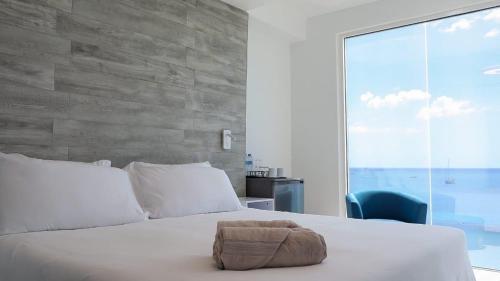 Un dormitorio con una cama blanca con una toalla encima. en One Love Motel, en Gros Islet