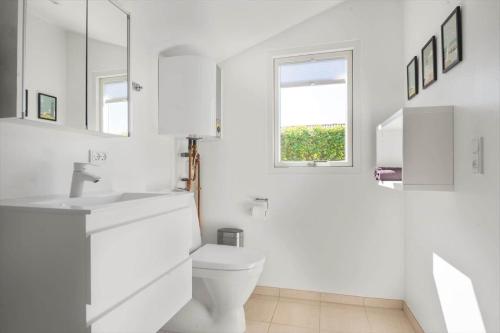 a white bathroom with a toilet and a window at 30020-Malling-Hyldevaenget-17 in Malling