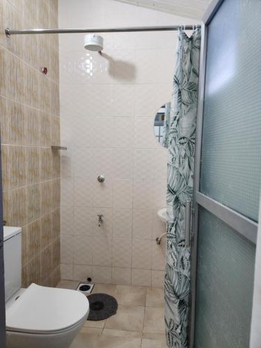 a bathroom with a toilet and a glass shower door at Modern Guest House 1BR in Nakuru