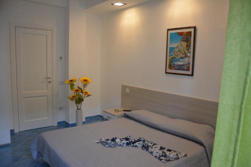 a bedroom with a bed and a vase of flowers at Acquamarine Maiori Amalfi Coast in Maiori