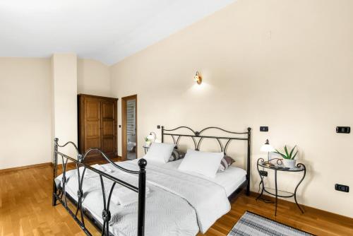 a bedroom with a bed with white walls and wooden floors at Villa Dol an ideal spa and wellness escape in Istria in Buzet