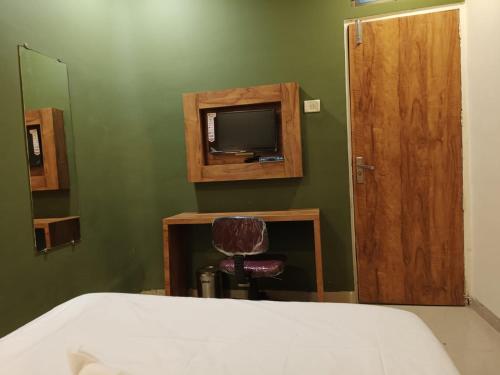 una camera da letto con un letto e una TV a parete di Glitz Hotels-Mumbai Inn-Saki Naka Junction a Mumbai