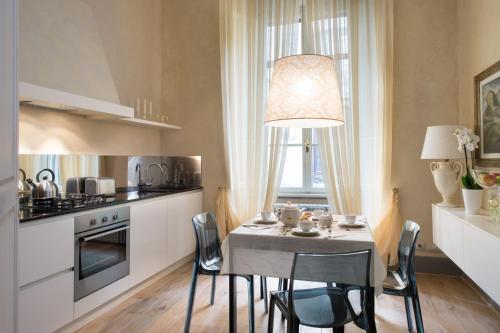 a kitchen with a table with chairs and a dining room at Roncioni Palace - Soggiorno Adriana in Pisa