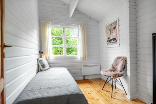 een kamer met een bed, een raam en een stoel bij 30353-Odder-Lyngmarksvej-17 in Odder