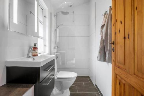 een witte badkamer met een toilet en een wastafel bij 30353-Odder-Lyngmarksvej-17 in Odder