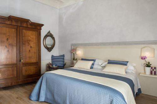 una camera da letto con un grande letto con lenzuola blu e bianche di Roncioni Palace - Soggiorno Adriana a Pisa